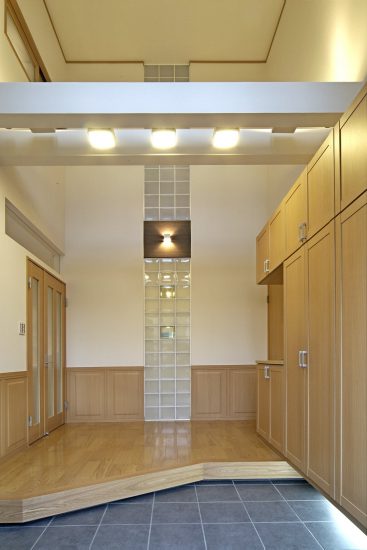 愛知県豊田市の注文住宅の吹き抜け、収納のある明るいデザインの玄関ホール