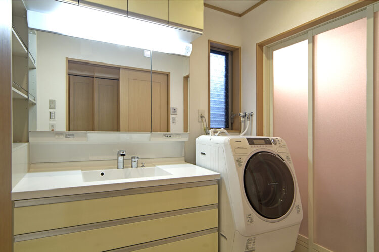 愛知県豊田市の注文住宅の黄色のパネルの洗面台と横に収納も付いた洗面室