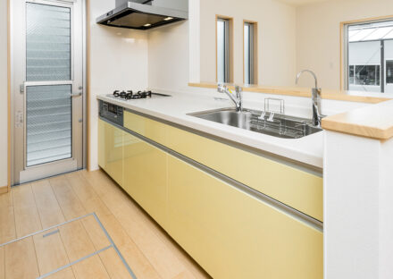 名古屋市中川区のおしゃれなデザインの注文住宅の黄色のパネルのシステムキッチン
