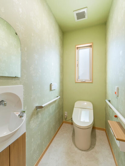 名古屋市中川区のおしゃれなデザインの注文住宅の緑色のおしゃれな壁紙のタンクレストイレ