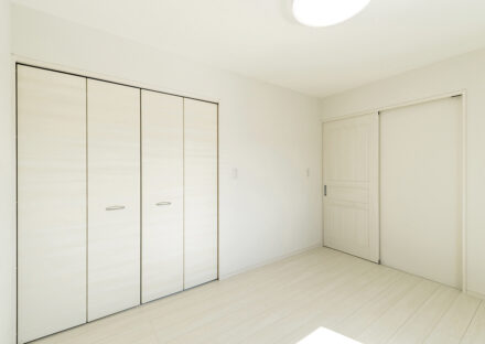 名古屋市中川区のおしゃれなデザインの注文住宅の白を基調にしたアンティーク調の引き戸が付いた洋室