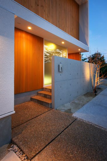名古屋市守山区の注文住宅のコンクリートと木の壁が組み合わされた玄関