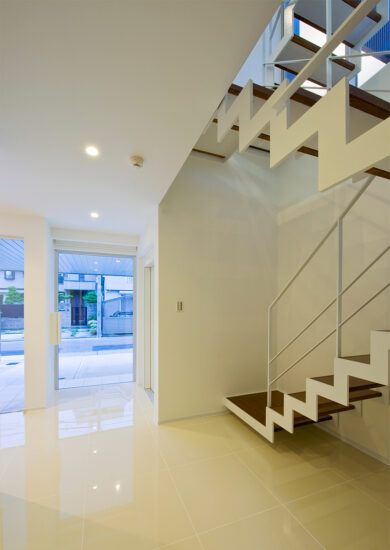 名古屋市千種区の鉄骨造3階建てデザイン注文住宅の玄関ホール横の特徴的なデザインの階段