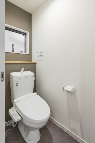 名古屋市南区の注文住宅の窓&棚付きの落ち着いた色のトイレ