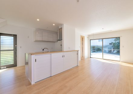 名古屋市名東区のシンプルなデザインの注文住宅のキッチンの裏に引き戸収納と吊戸棚のあるLDK