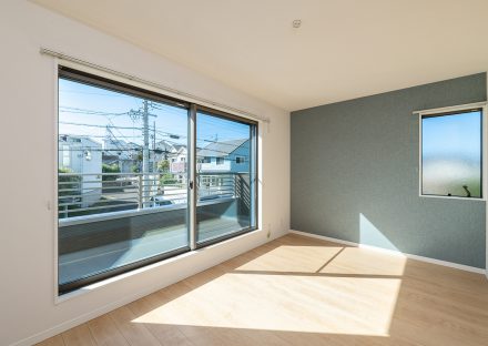 名古屋市名東区のシンプルなデザインの注文住宅のバルコニーの付いた明るい洋室