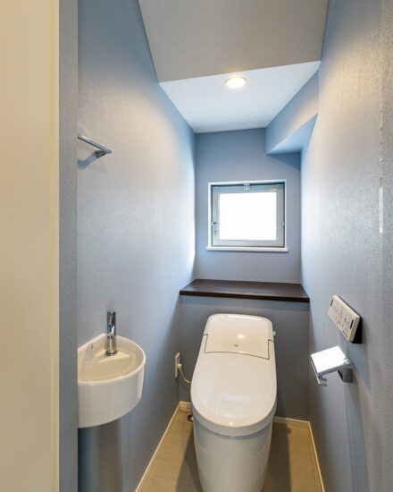 愛知県知多郡阿久比町のモダンなデザインの注文住宅の手洗い場と窓の付いたタンクレスのすっきりしたおしゃれなトイレ
